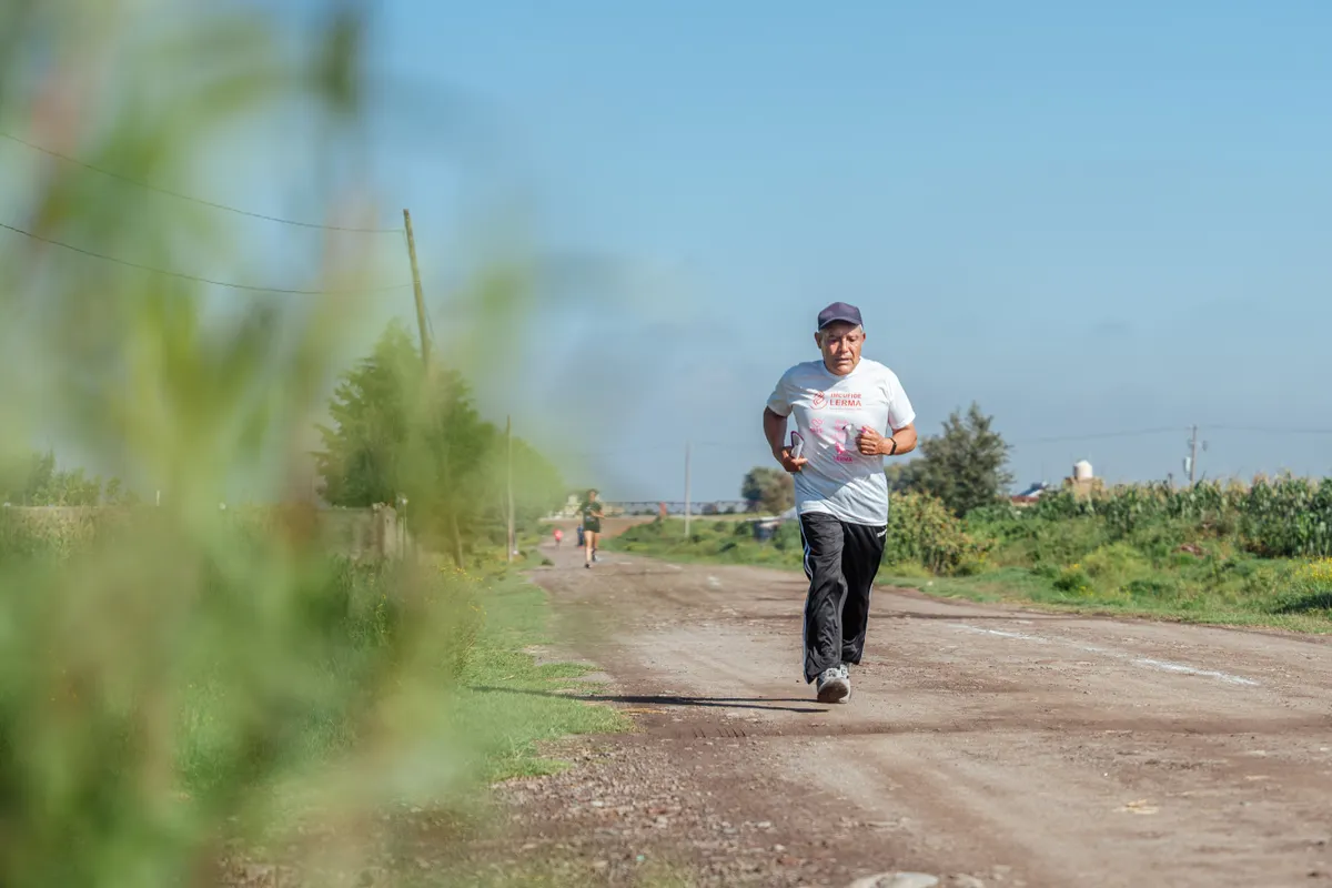 Older man running along a quiet rural dirt road
