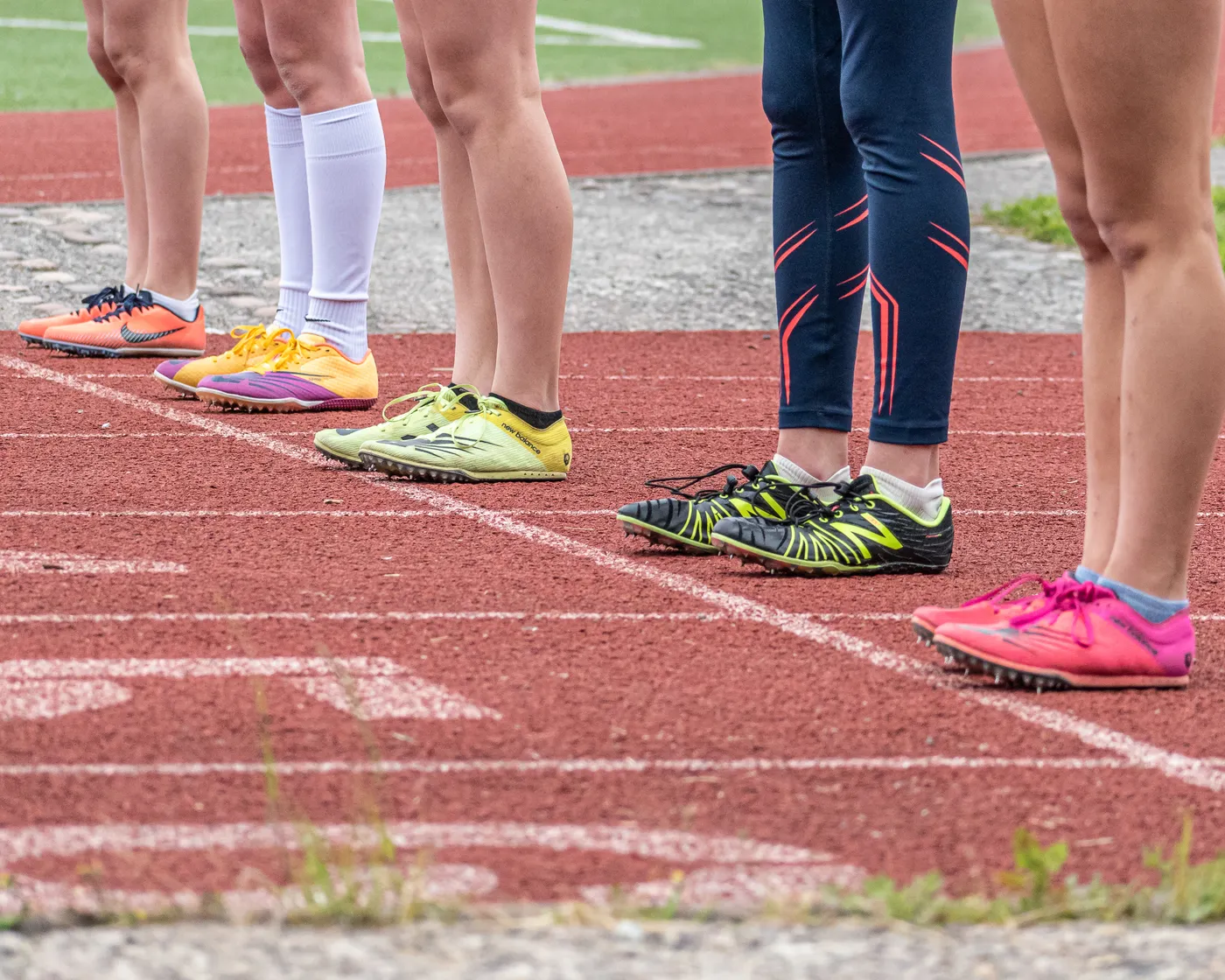 Runners' shoes lined up on an outdoor athletics track