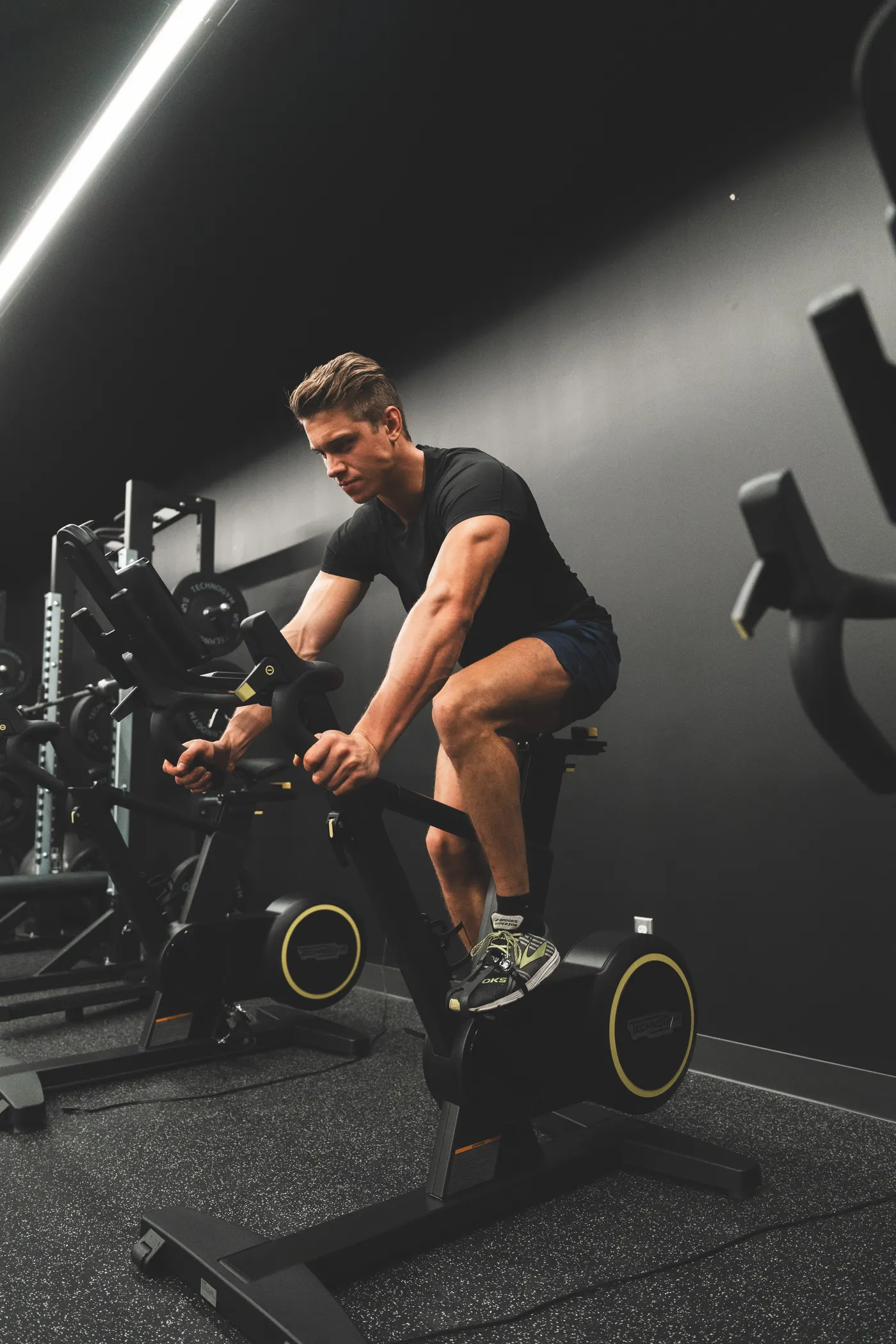 Athlete pedaling a stationary bike in a gym