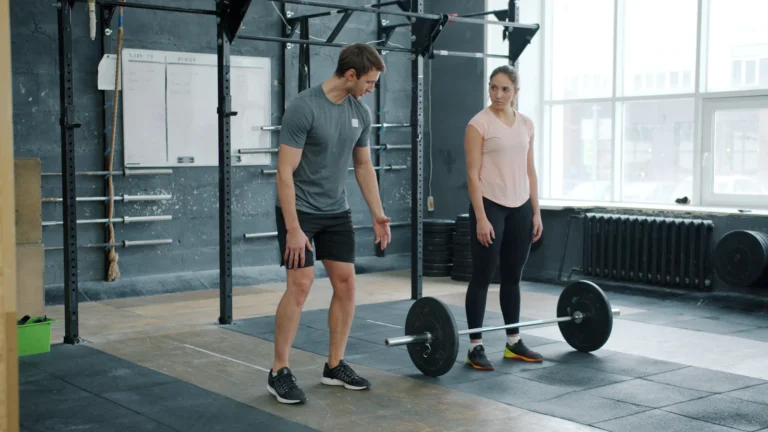Trainer discussing barbell technique with an athlete