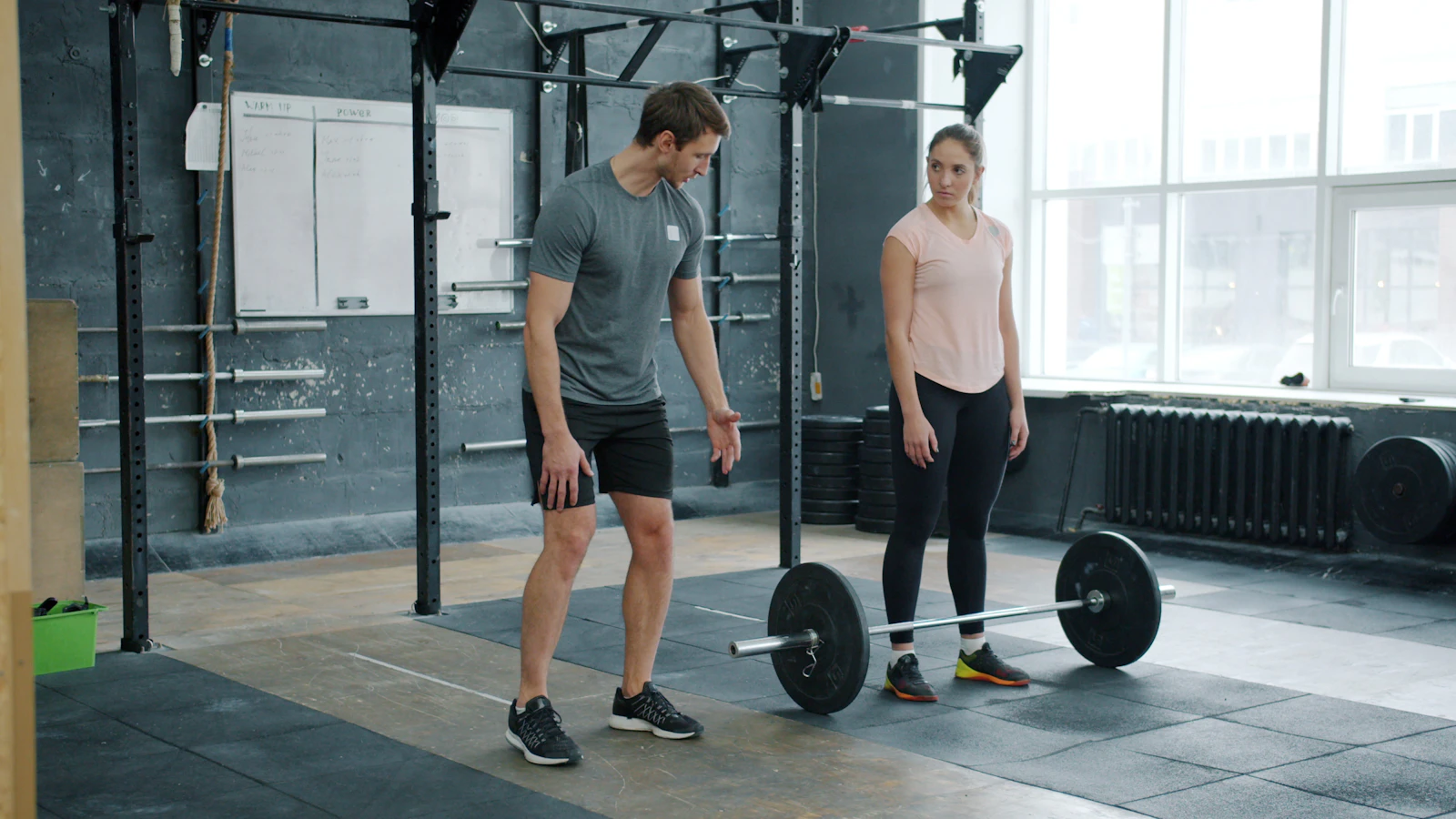 Trainer discussing barbell technique with an athlete