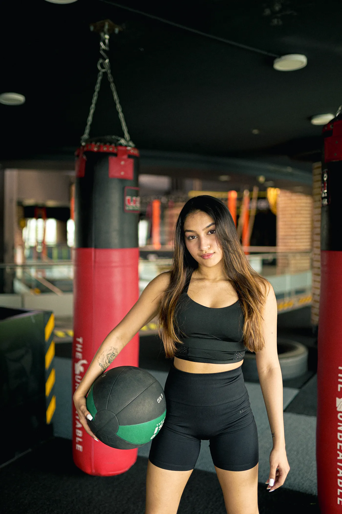 Woman holding a medicine ball in a boxing gym