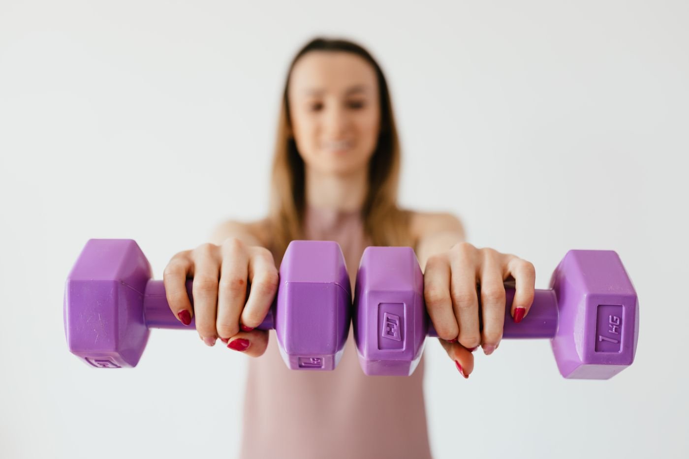 Woman holding purple dumbbells during a strength workout