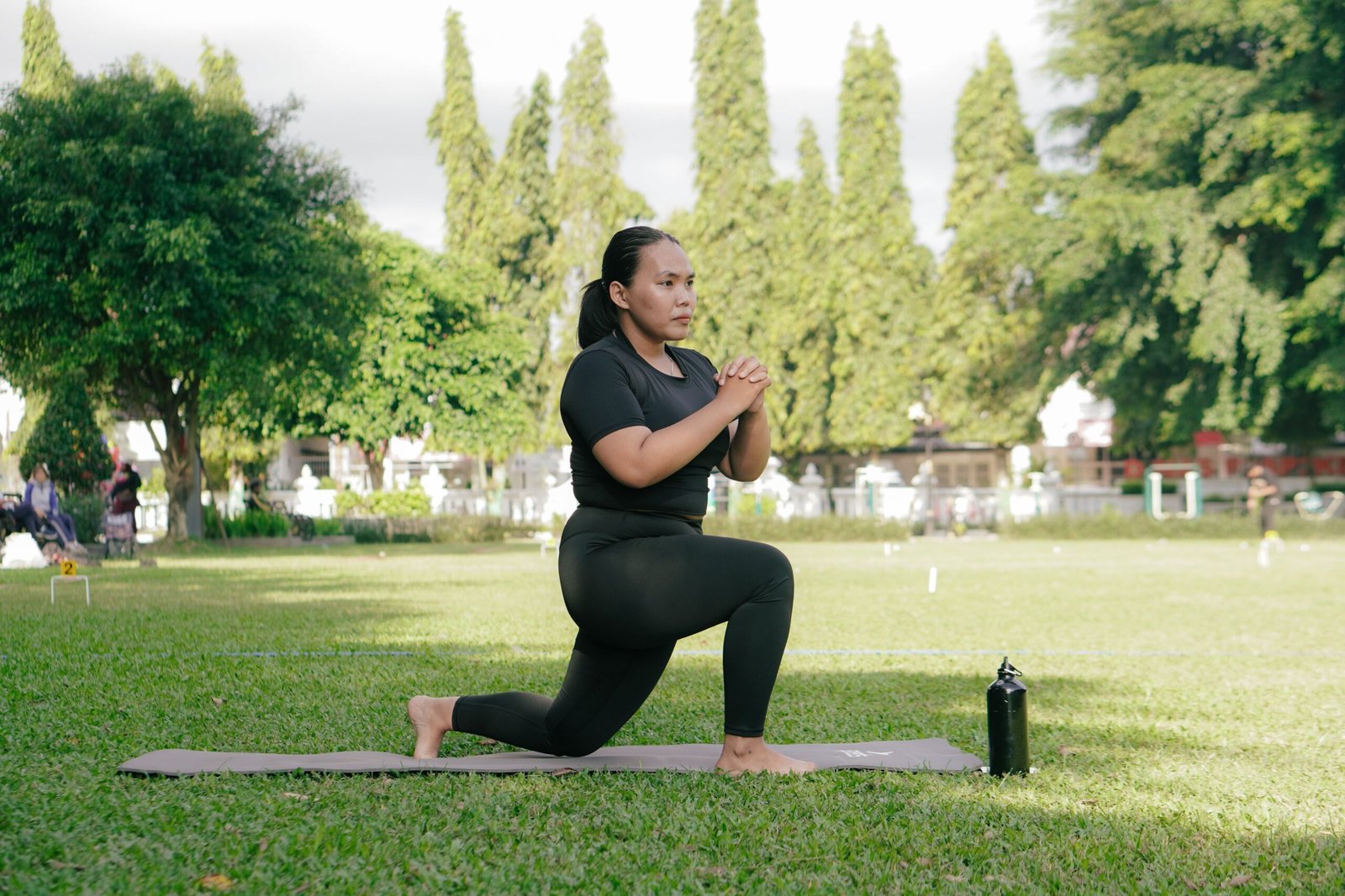 Woman practicing an unweighted lunge outdoors