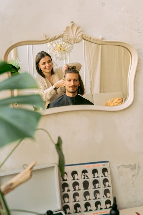 Barber styling a man's hair in a salon