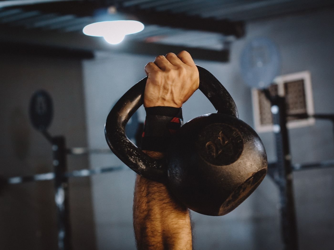 Close view of a hand holding a kettlebell in a gym