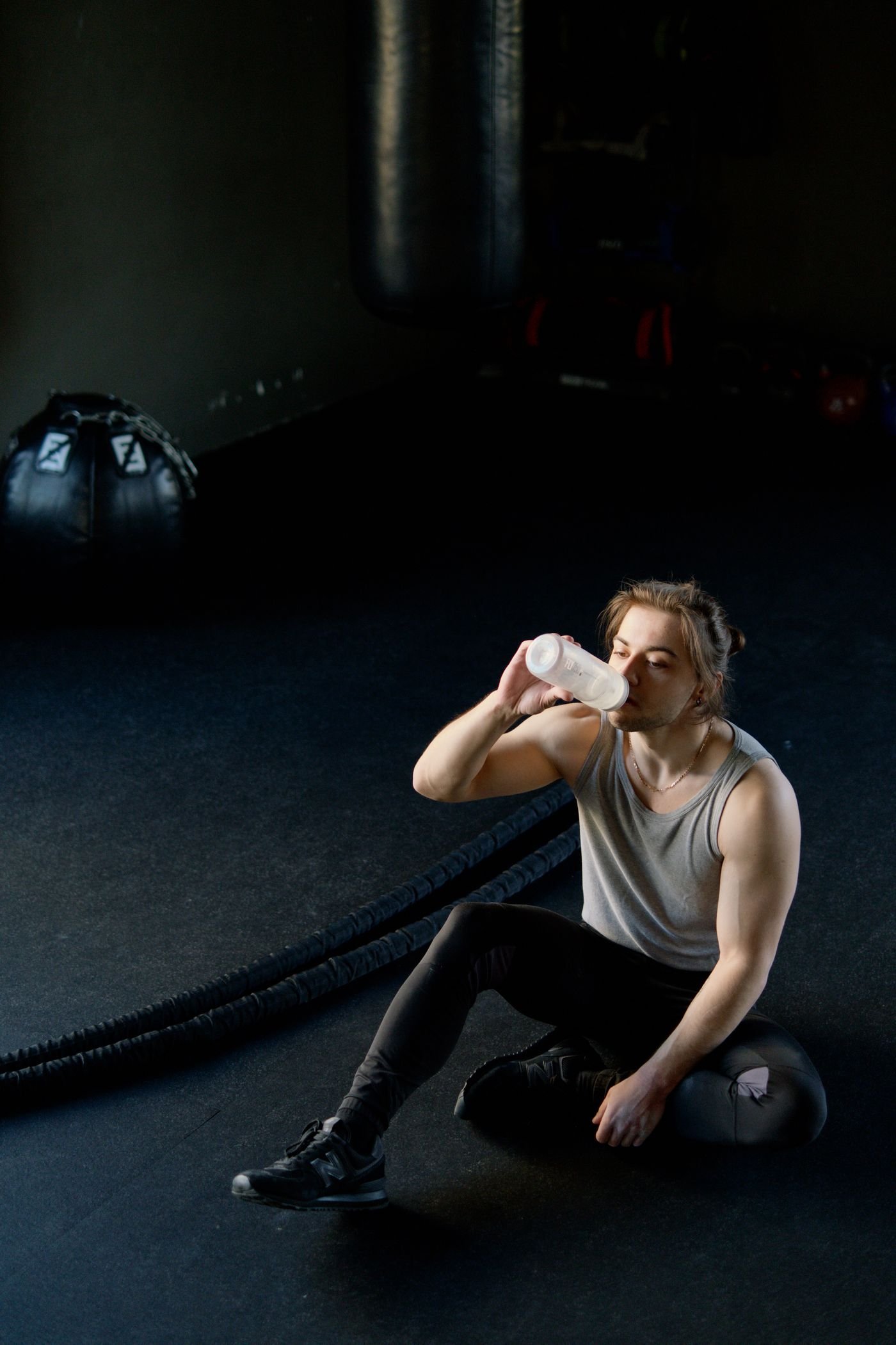 Man hydrating after exercise while seated in a gym