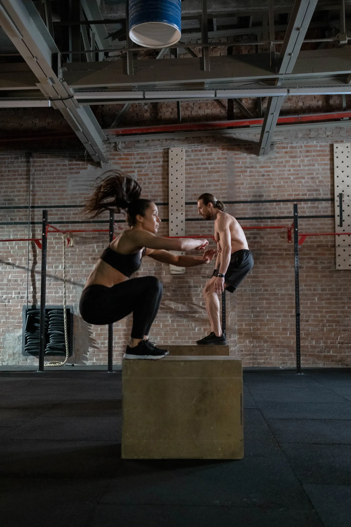 Two athletes performing plyometric box-jump training