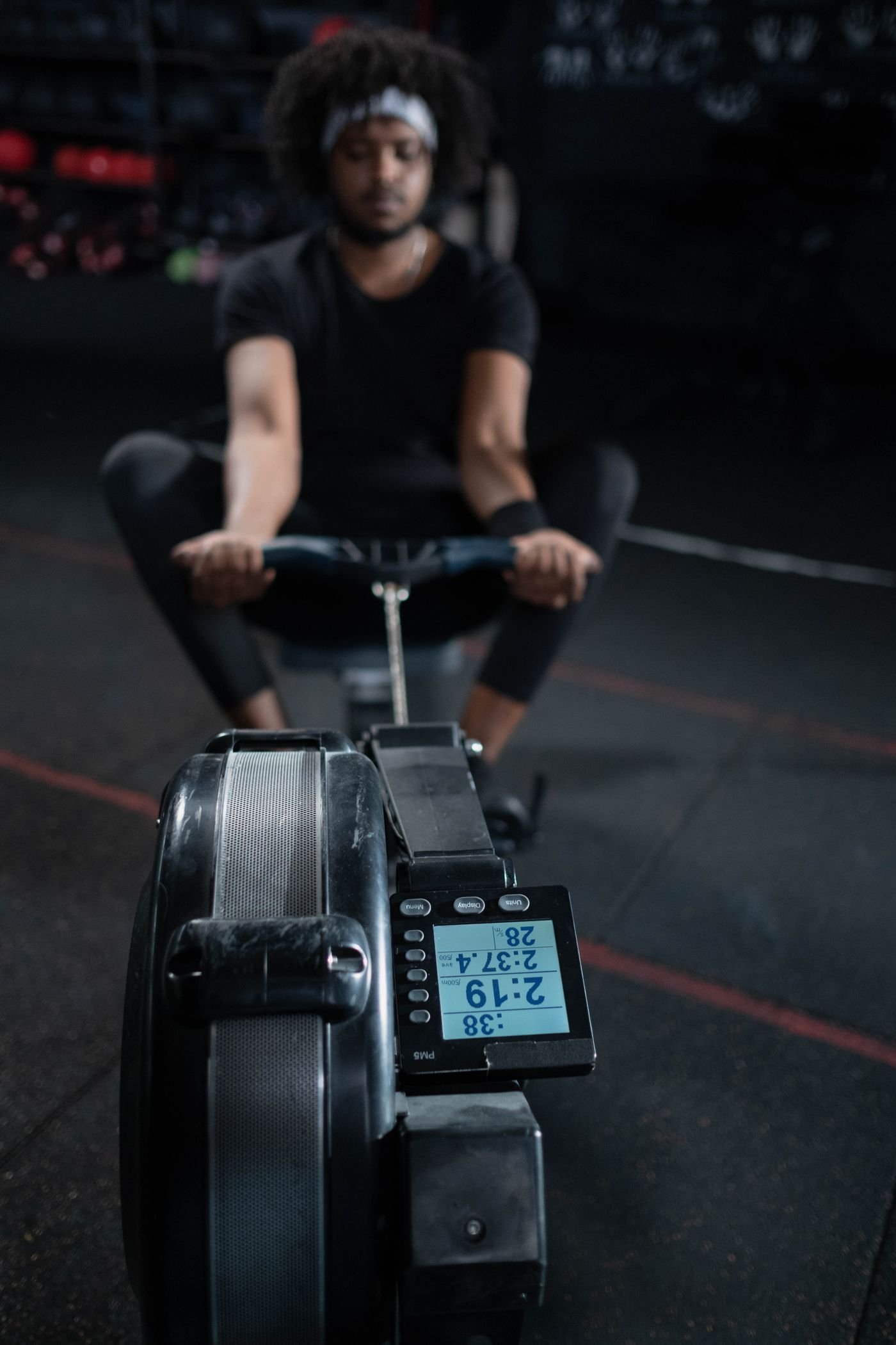 Man performing steady rowing intervals on an indoor rowing machine