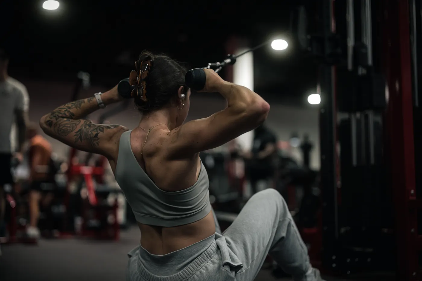 Woman performing a controlled cable-machine strength exercise