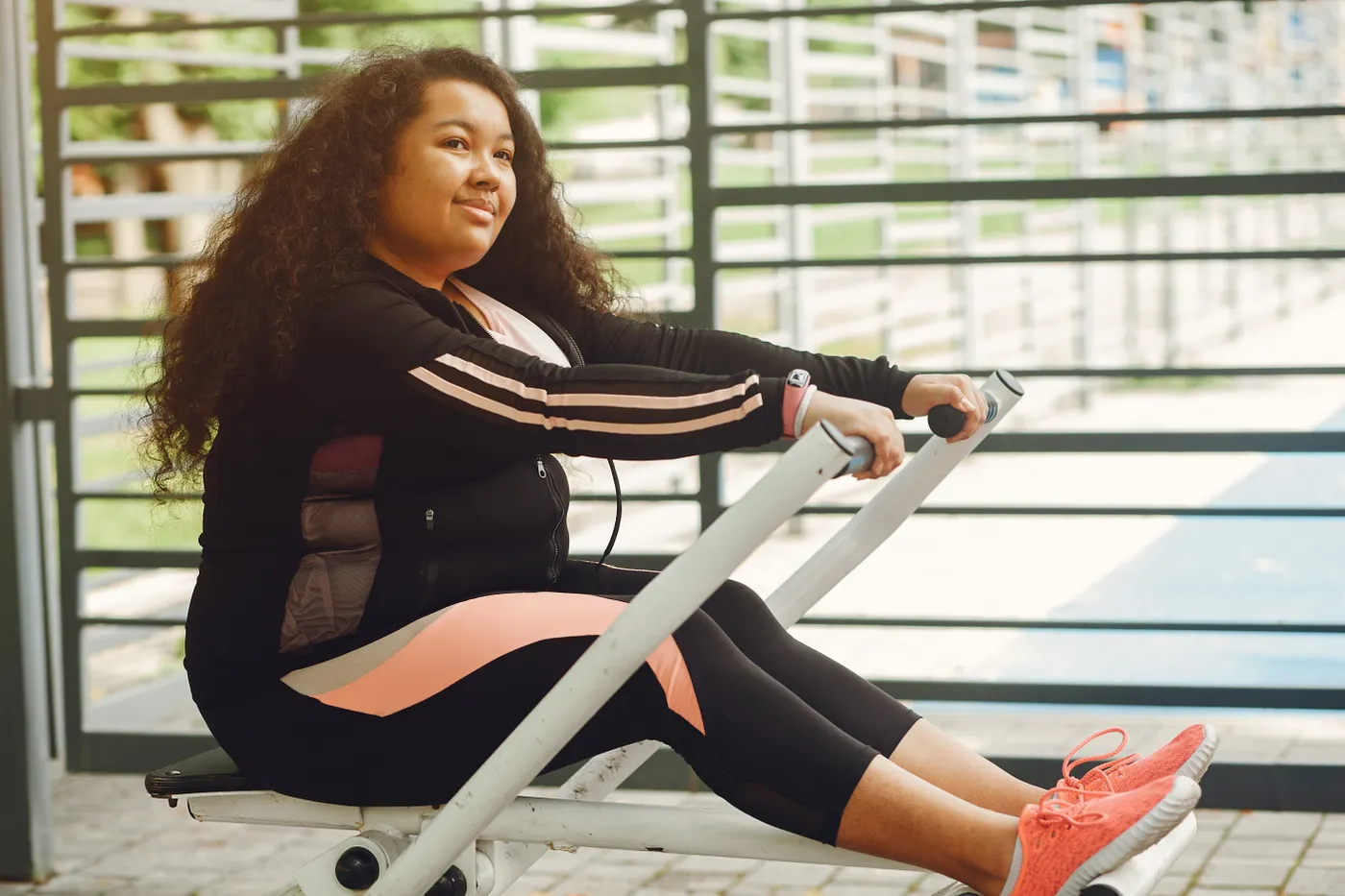 Woman using an outdoor rowing machine for a fitness workout