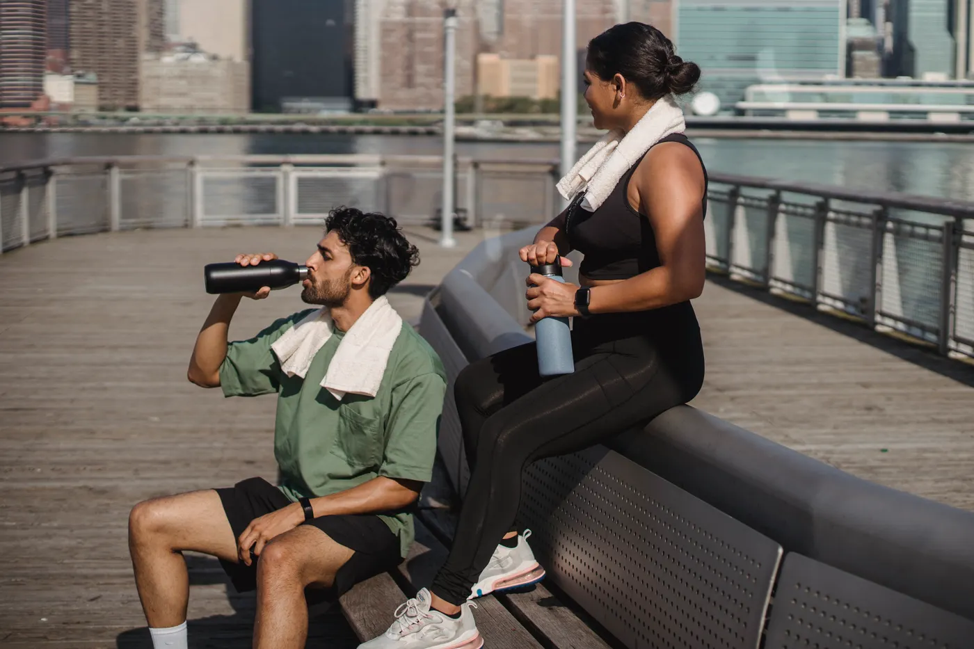 Two athletes resting and hydrating after exercise