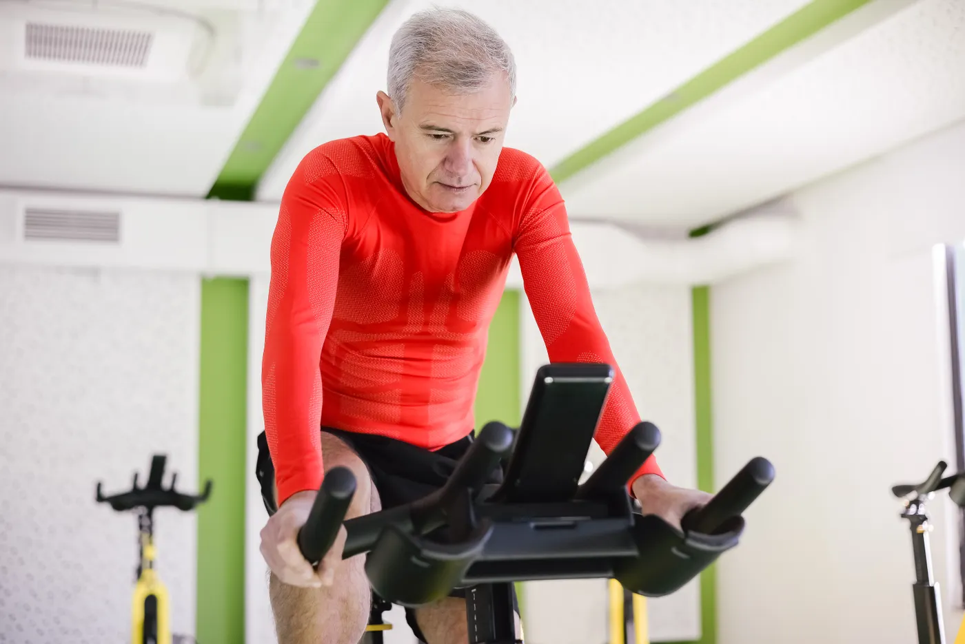 Older man exercising on a stationary bike indoors