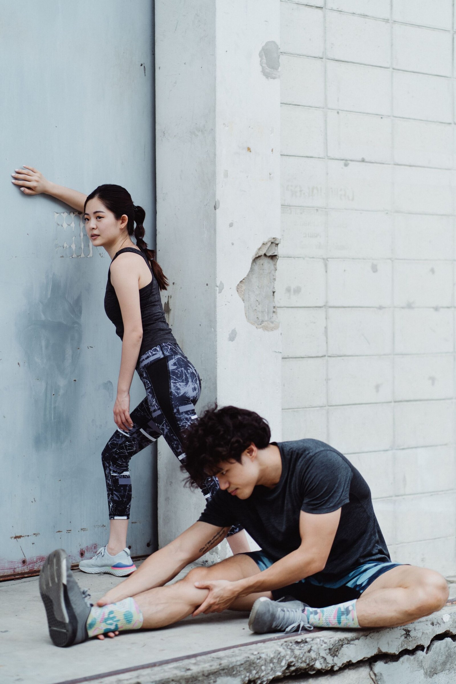 Two athletes stretching outdoors before a workout