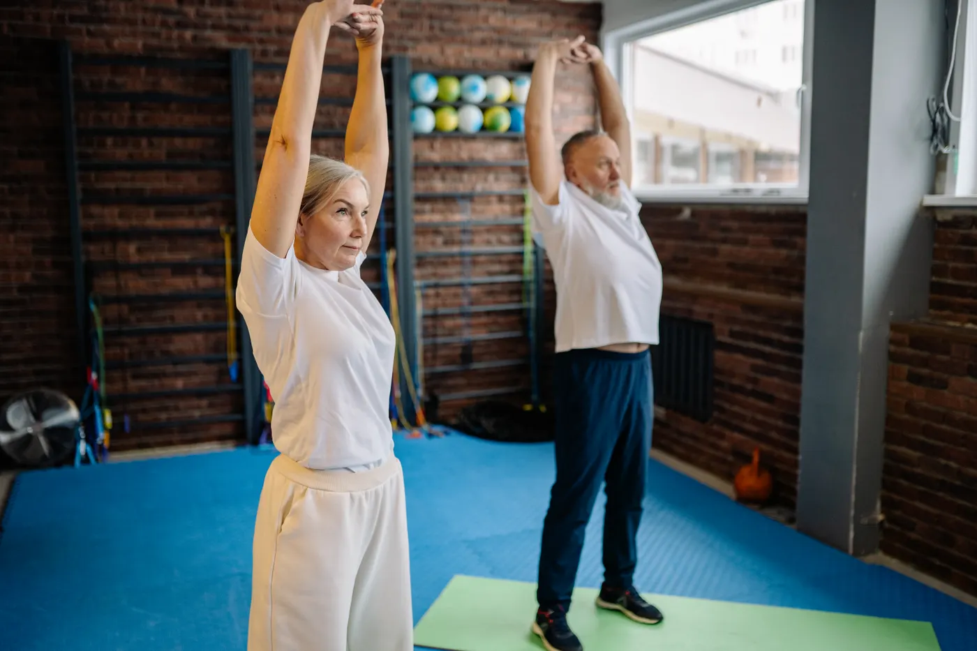 Older adults stretching together in a gym