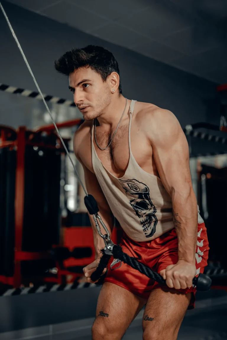 Man training triceps with a cable attachment in a gym