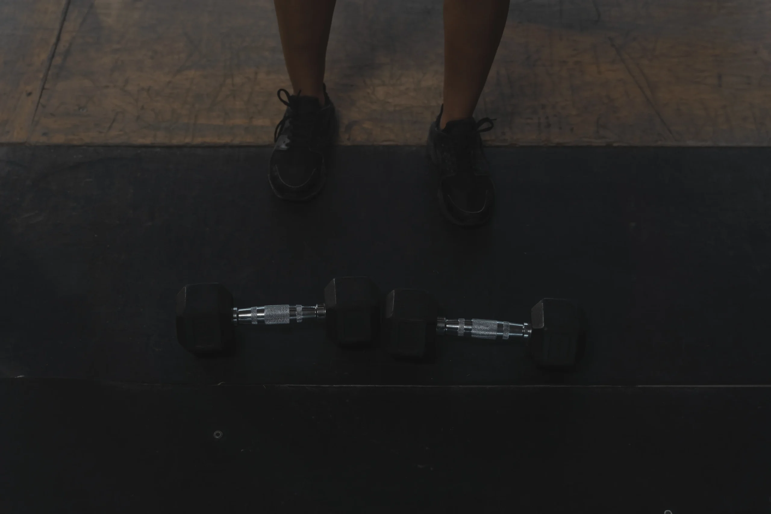 Athlete standing behind dumbbells before a workout