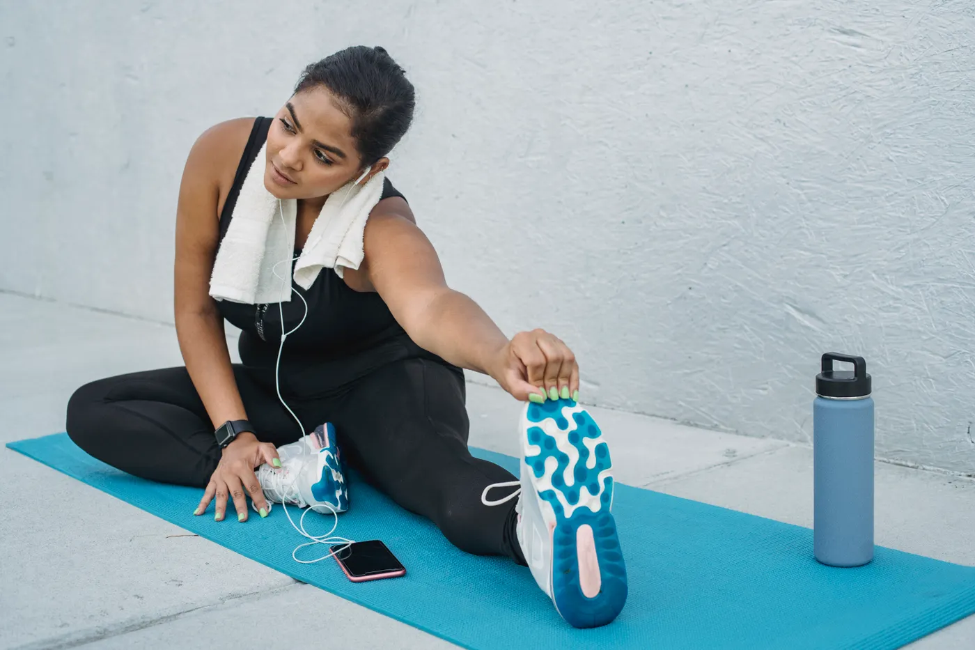 Woman stretching on a mat before exercise