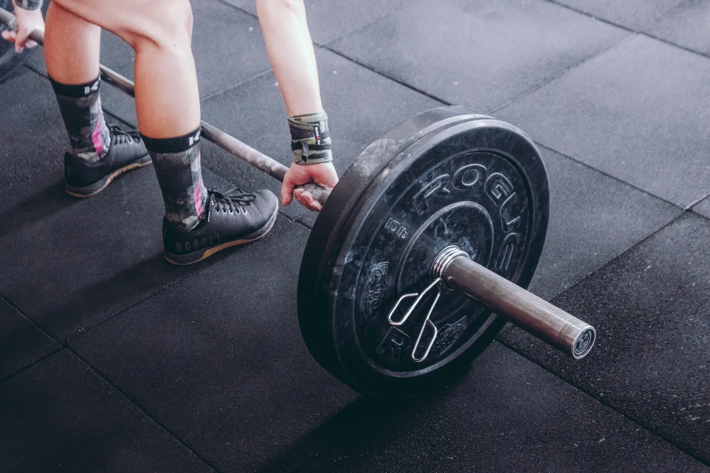 Close view of a lifter holding a barbell in a gym