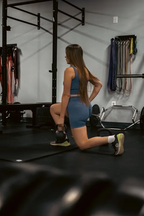 Athlete using a kettlebell during a controlled lunge
