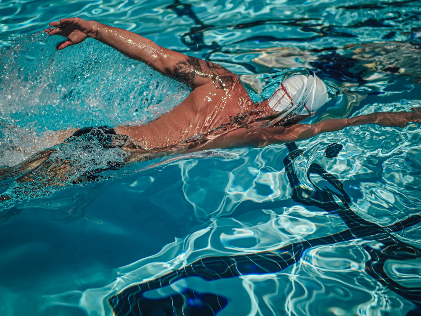 Athlete swimming freestyle in an outdoor pool