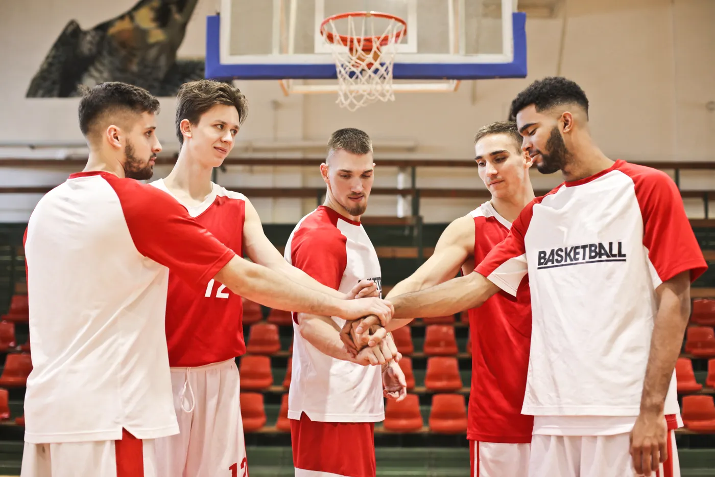 Male basketball players gathering in a team huddle before practice