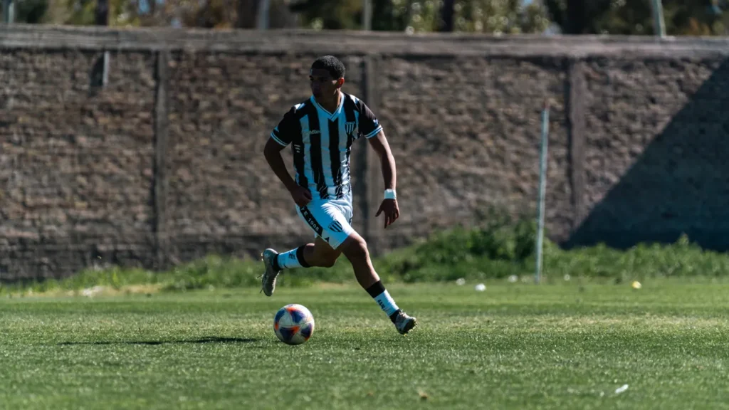 Soccer player dribbling the ball during a competitive match on grass