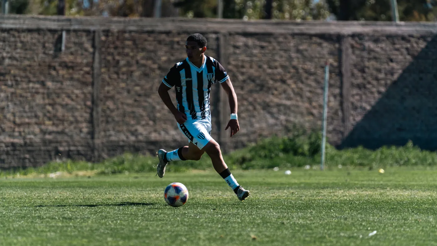 Soccer player dribbling the ball during a competitive match on grass
