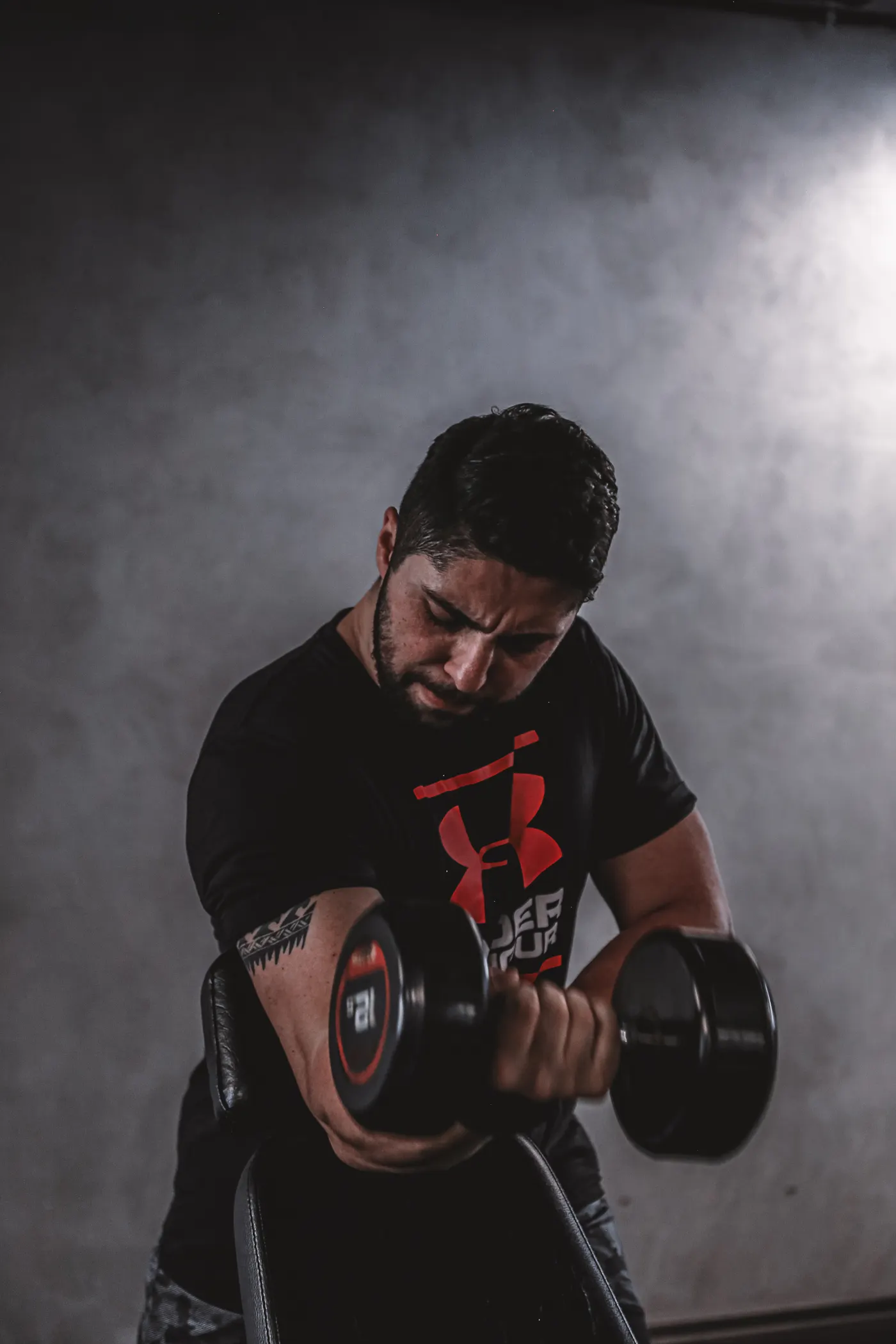 Athlete training his arms with a dumbbell in a gym