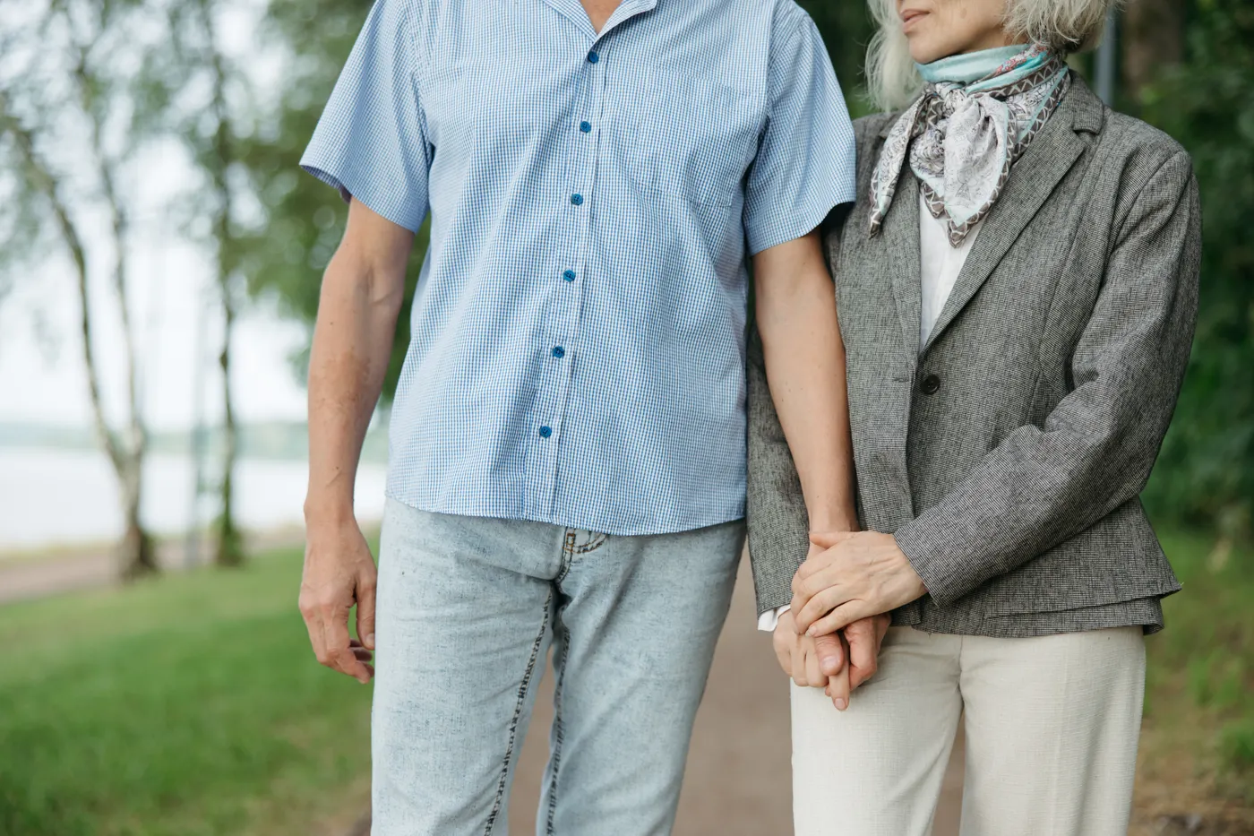 Older couple walking together in a green park