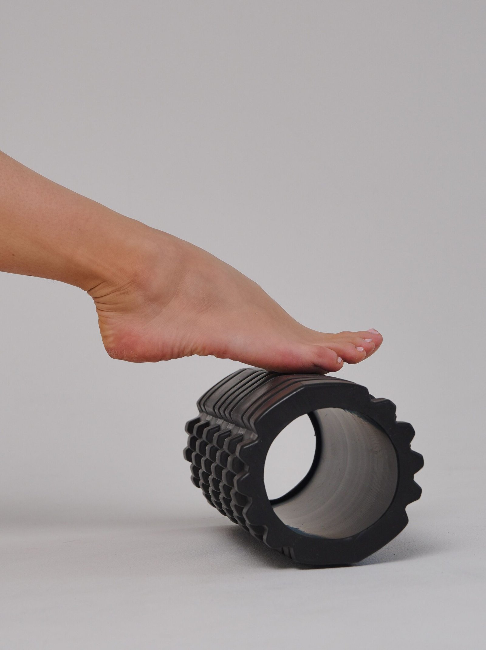 Close-up of a foot pressing onto a foam roller