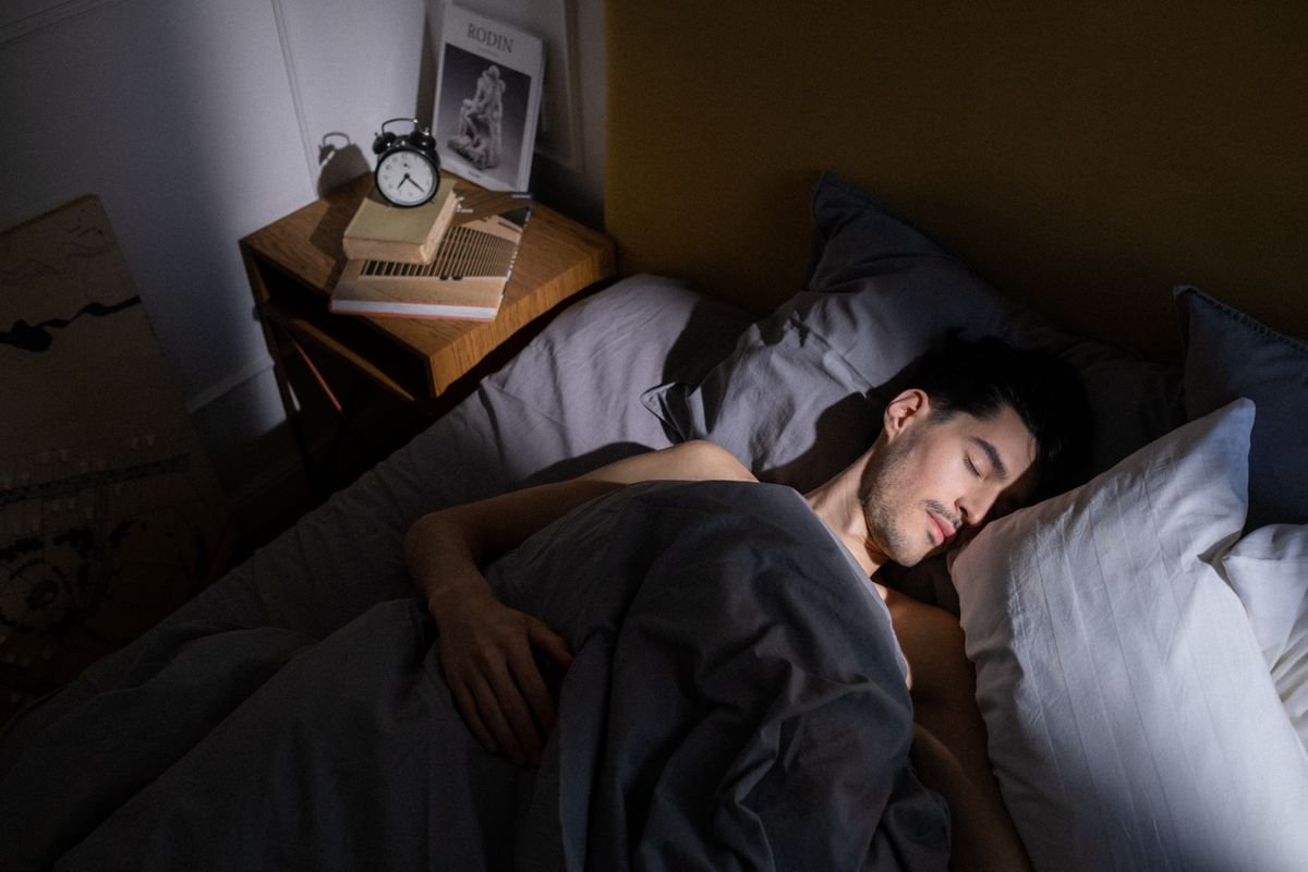 Man resting in bed with morning sunlight