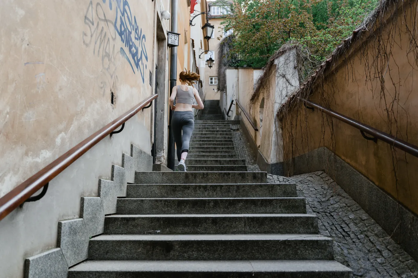 Rear view of a woman climbing outdoor steps during exercise