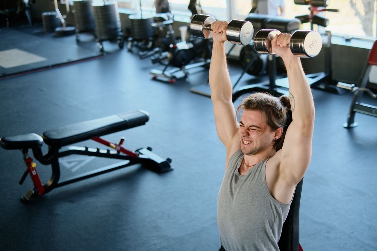 Man lifting dumbbells in a gym during a strength training session