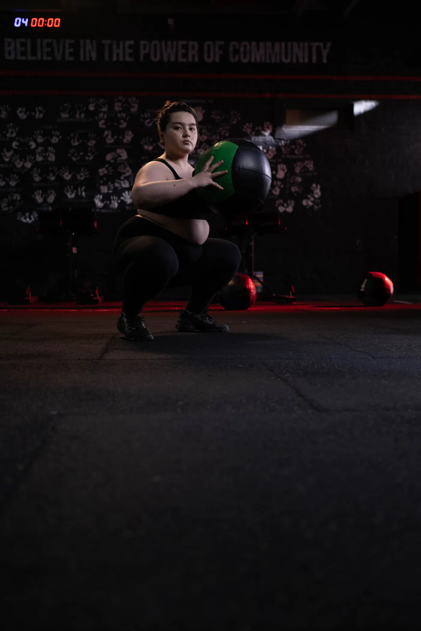 Woman performing a controlled squat with a medicine ball