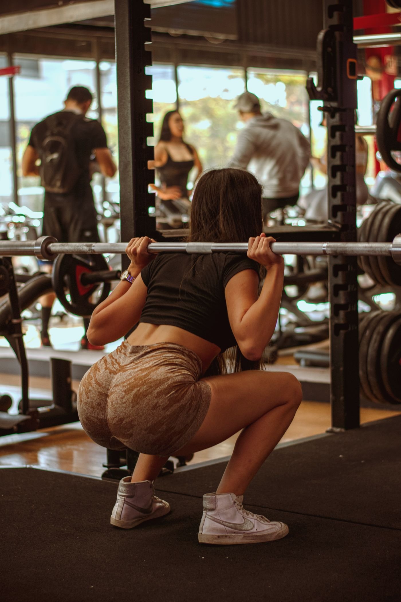 Athlete performing a deep barbell squat in a gym