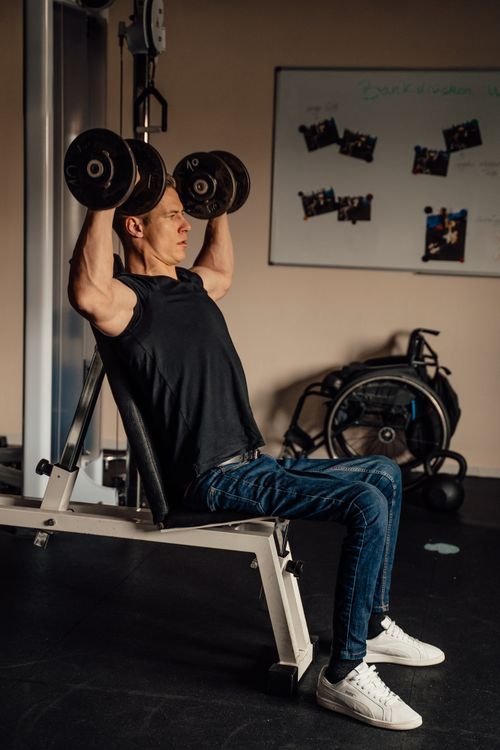 Man performing a seated dumbbell shoulder press