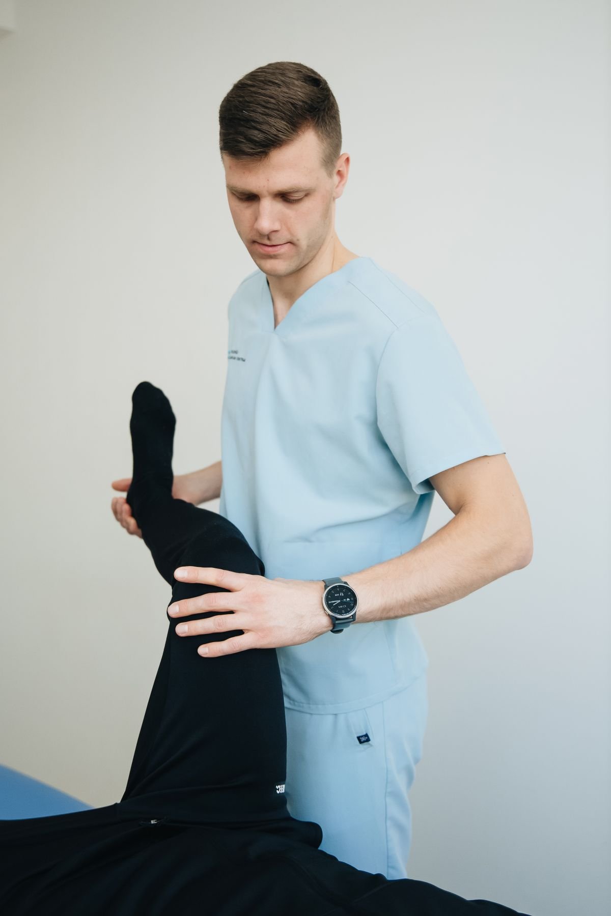 Physiotherapist guiding a patient's leg rehabilitation exercise