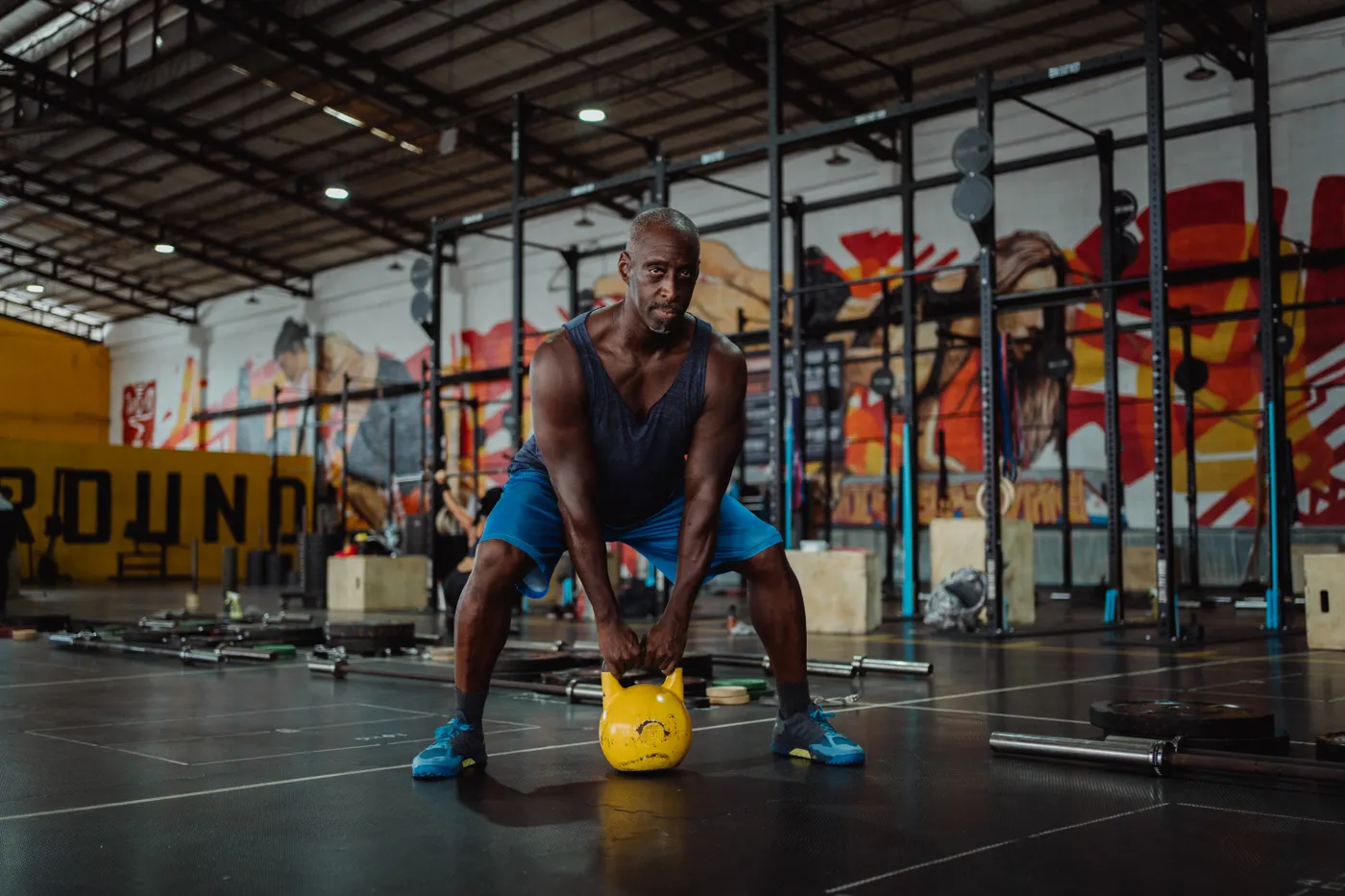 Man lifting a kettlebell in a gym