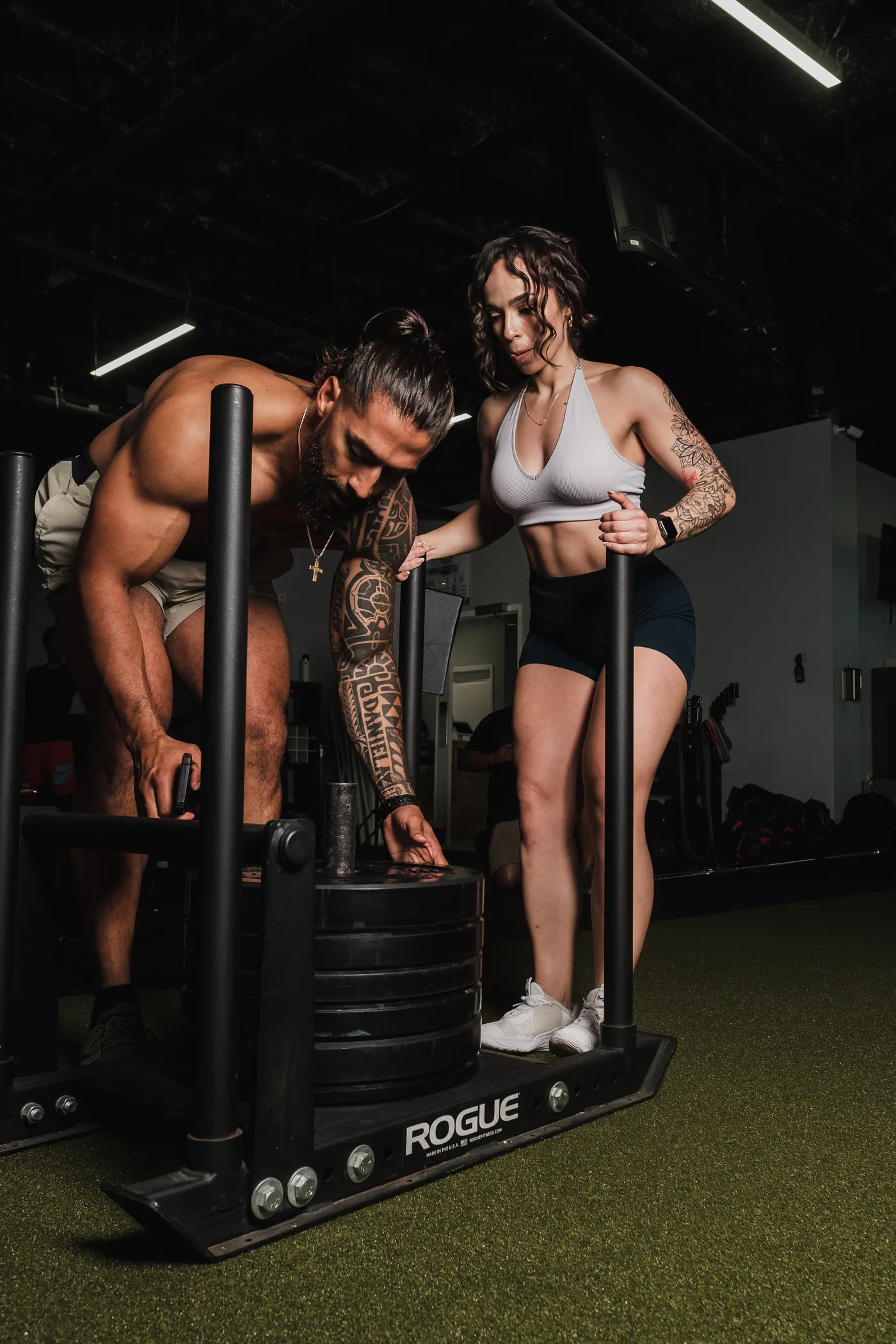 Two athletes training with a push sled