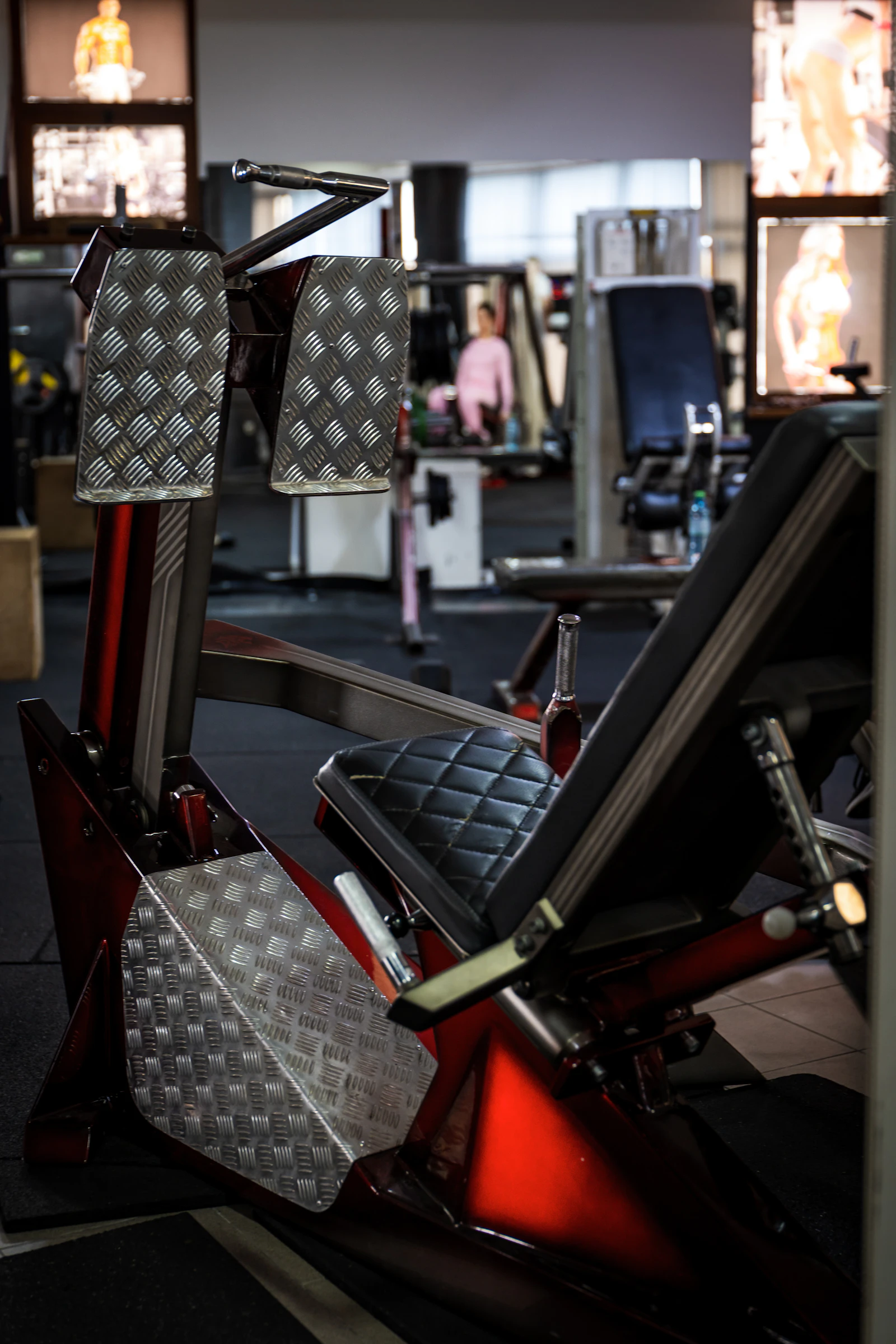 Red leg press machine in a gym for lower-body resistance training