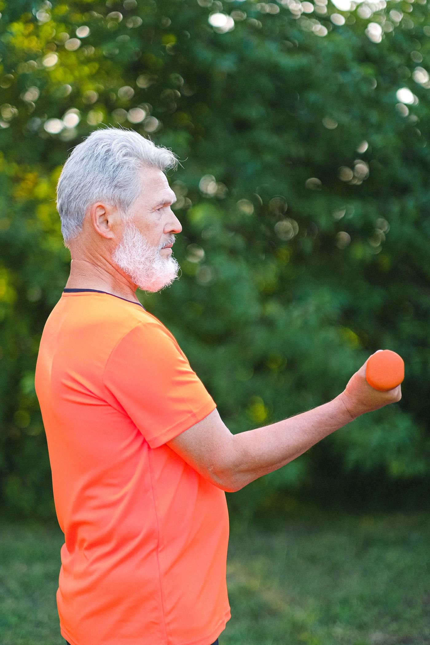 Senior man exercising with a dumbbell in an outdoor park