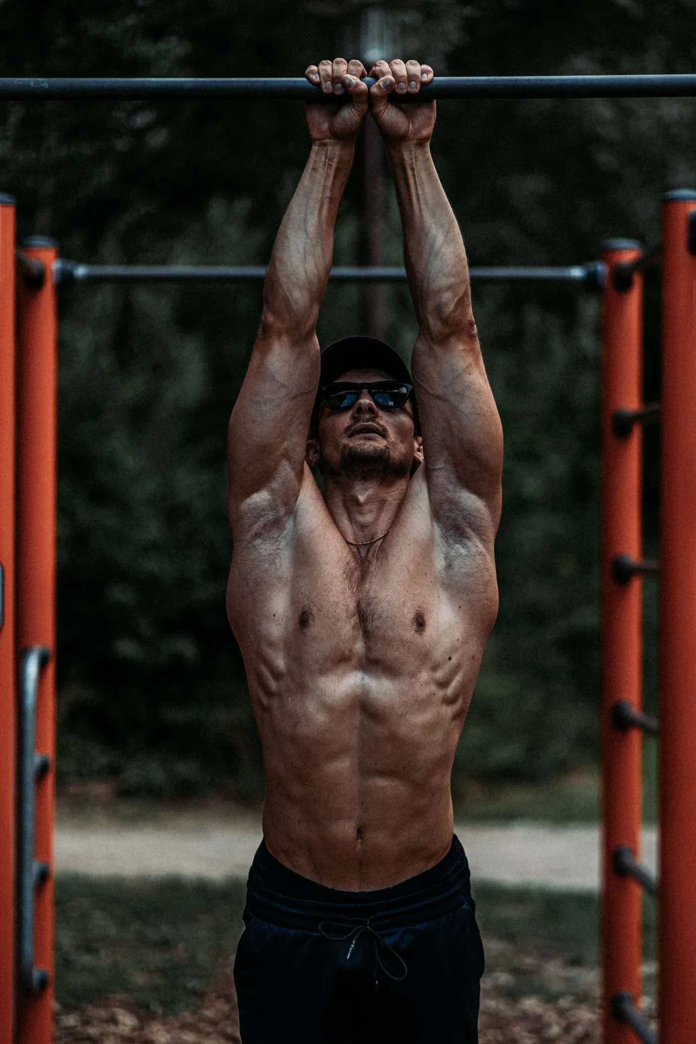 Man training pull-ups on an outdoor exercise bar