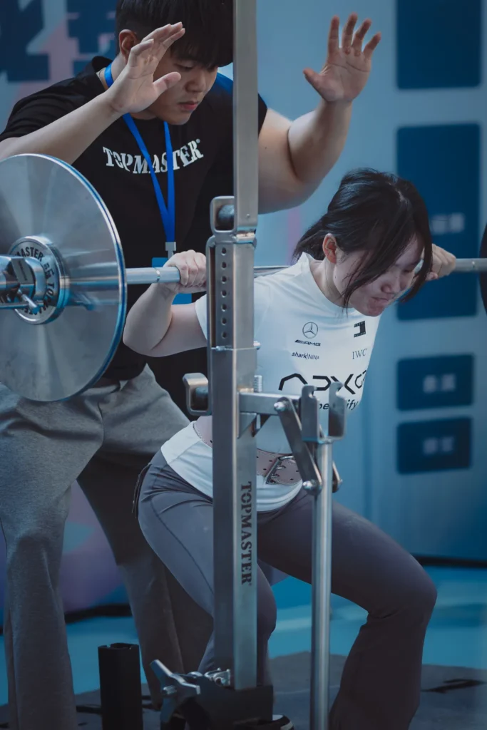 Personal trainer assisting a woman during weightlifting