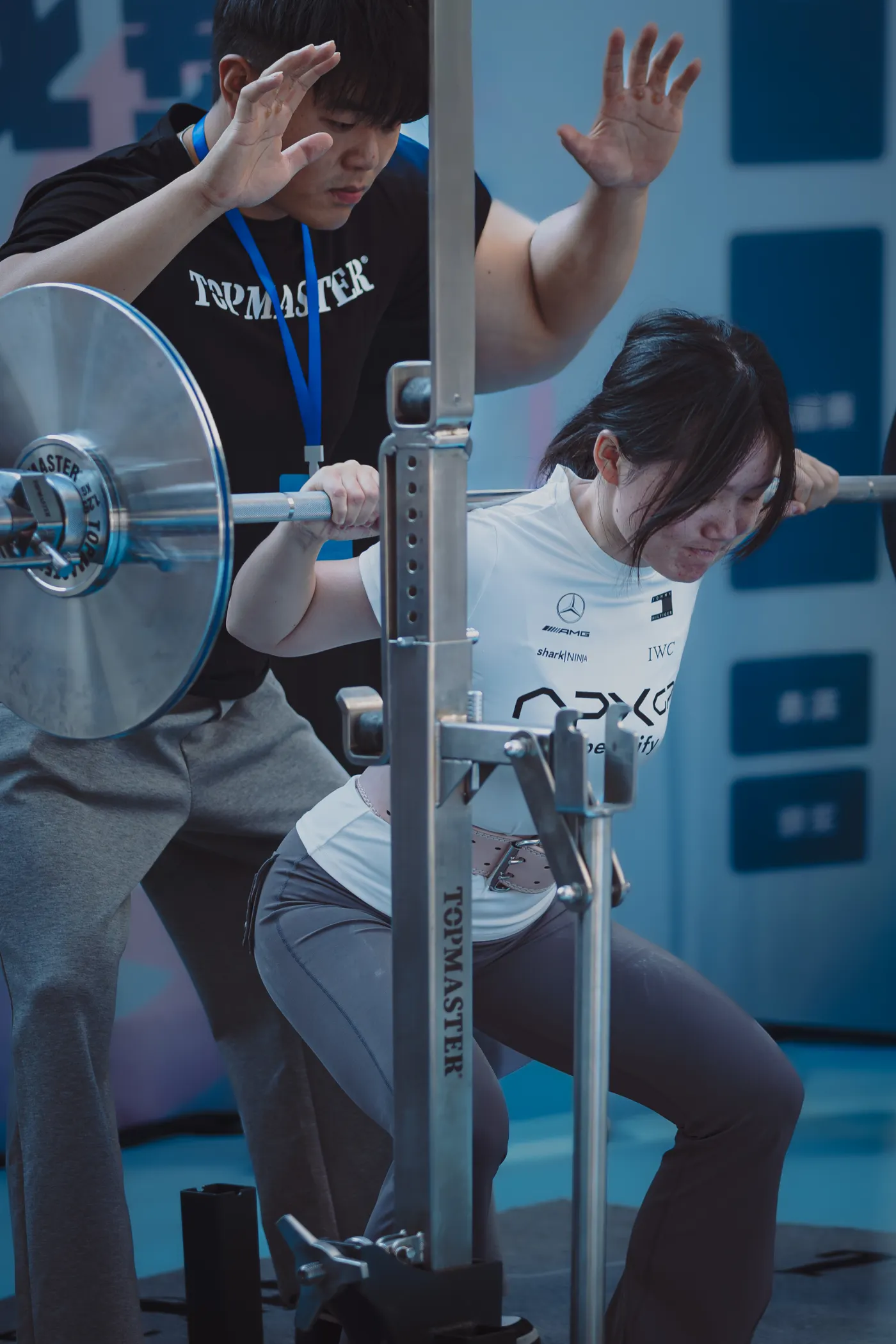 Personal trainer assisting a woman during weightlifting