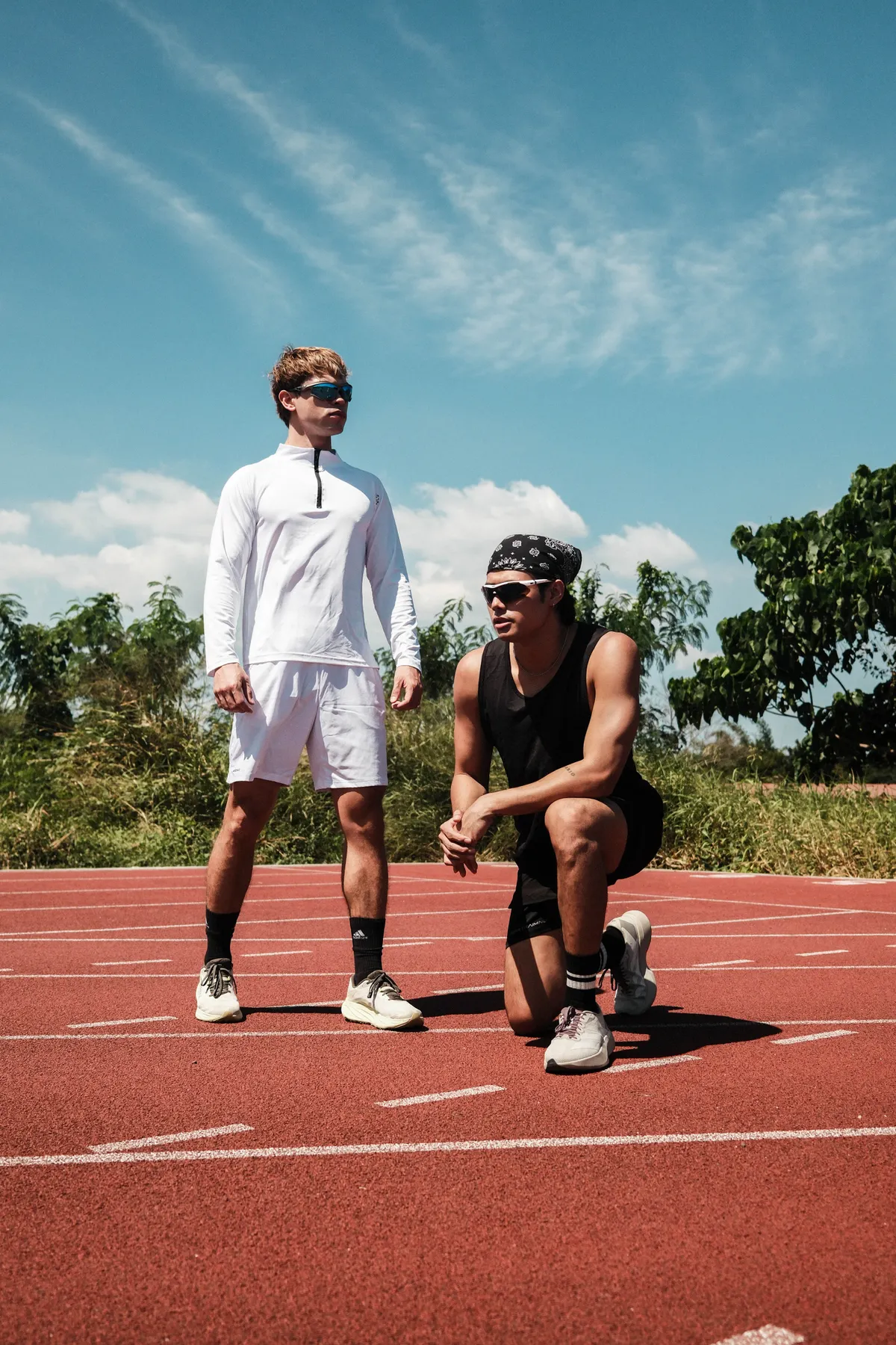 Two runners preparing for a track workout with speed intervals