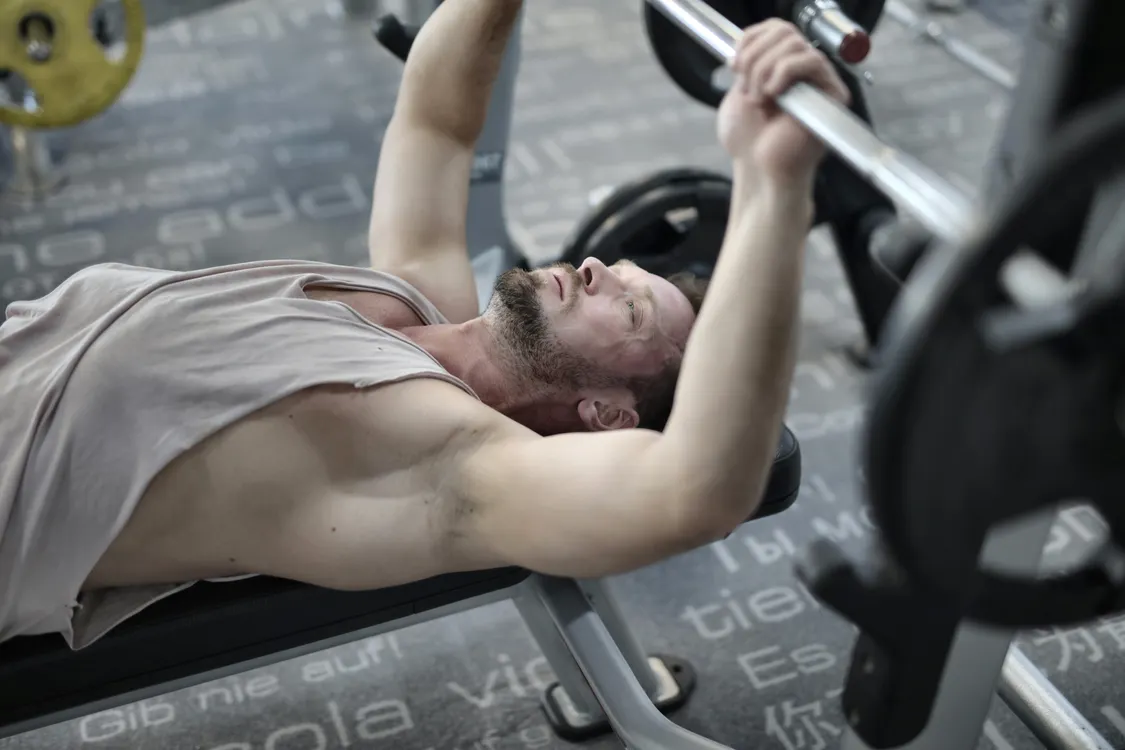 Athlete controlling a barbell during a bench press