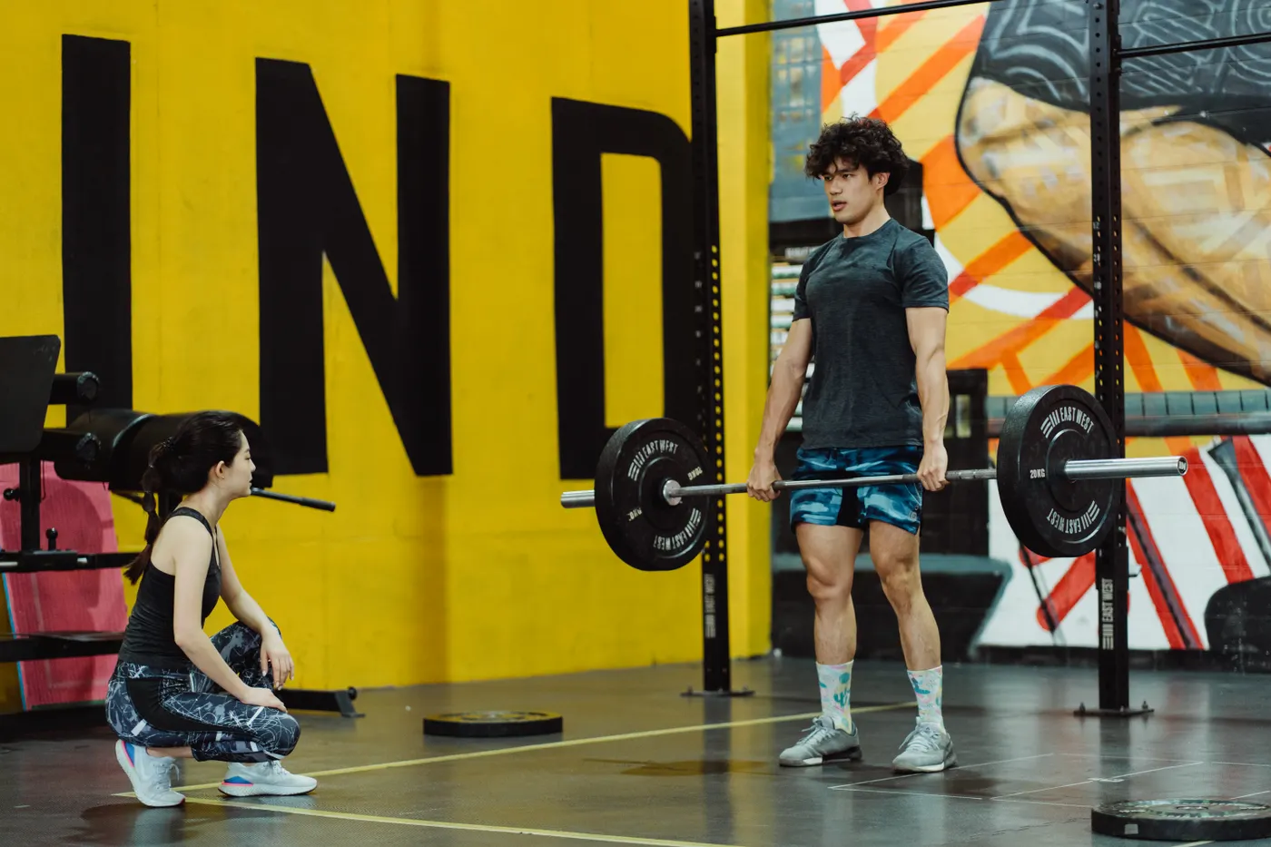 Person practicing a barbell deadlift in a gym