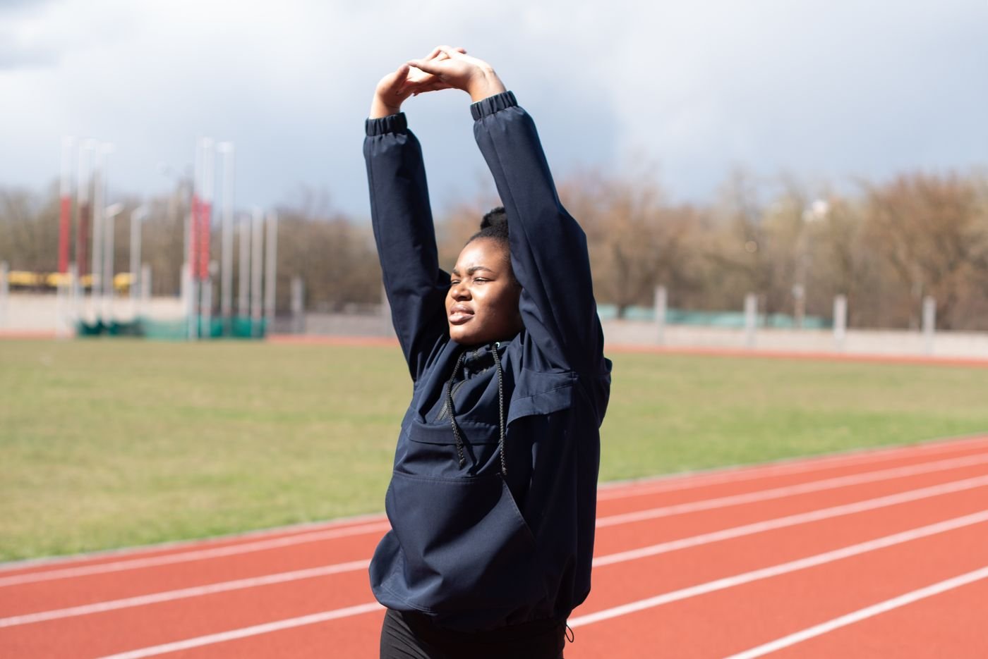 Runner stretching on a red track