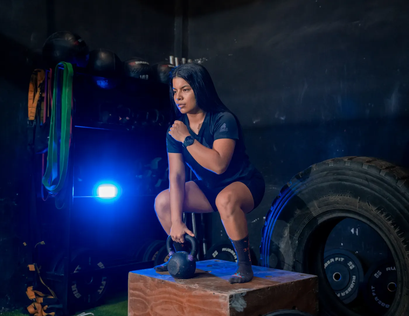 Woman performing a kettlebell squat during a gym strength session